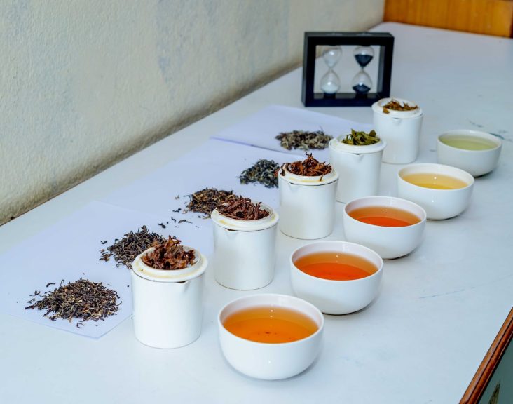 a table topped with cups filled with different types of tea
