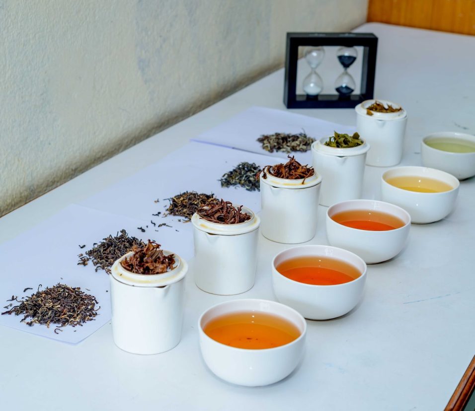 a table topped with cups filled with different types of tea